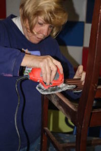 Artist Toni Mason, owner of Sew Crafty in Durham, works on sanding her chair at the artist workday held at The Scrap Exchange on February 5th.