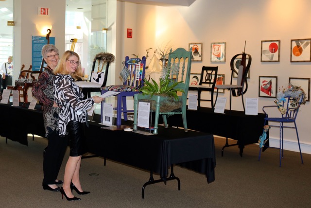 Kathy Silbiger and Ellen Ciompi prepare some of the musical chairs for        exhibition in the Allenton Gallery on March 5.